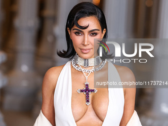 Kim Kardashian wearing a custom Gucci dress and coat with a Tallarico pearl choker, Bvlgari pearl and diamond necklace, and Princess Diana's...