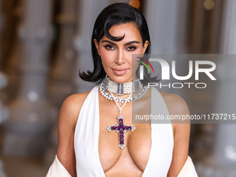 Kim Kardashian wearing a custom Gucci dress and coat with a Tallarico pearl choker, Bvlgari pearl and diamond necklace, and Princess Diana's...