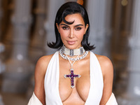 Kim Kardashian wearing a custom Gucci dress and coat with a Tallarico pearl choker, Bvlgari pearl and diamond necklace, and Princess Diana's...