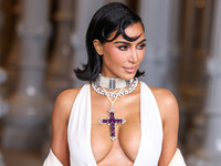 Kim Kardashian wearing a custom Gucci dress and coat with a Tallarico pearl choker, Bvlgari pearl and diamond necklace, and Princess Diana's...