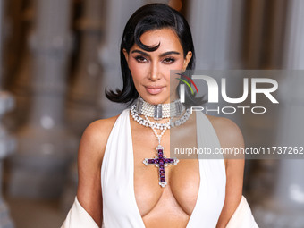 Kim Kardashian wearing a custom Gucci dress and coat with a Tallarico pearl choker, Bvlgari pearl and diamond necklace, and Princess Diana's...