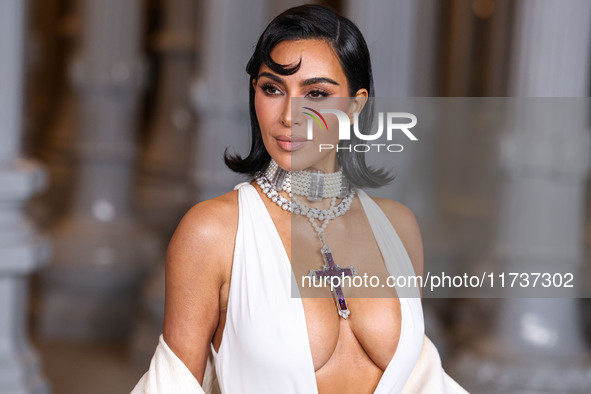 Kim Kardashian wearing a custom Gucci dress and coat with a Tallarico pearl choker, Bvlgari pearl and diamond necklace, and Princess Diana's...