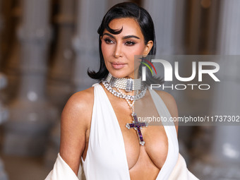 Kim Kardashian wearing a custom Gucci dress and coat with a Tallarico pearl choker, Bvlgari pearl and diamond necklace, and Princess Diana's...