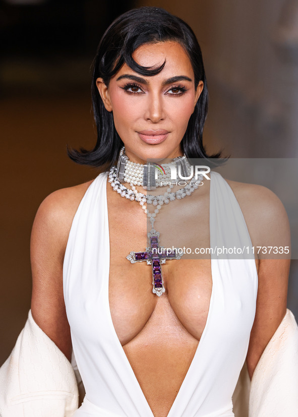 Kim Kardashian wearing a custom Gucci dress and coat with a Tallarico pearl choker, Bvlgari pearl and diamond necklace, and Princess Diana's...