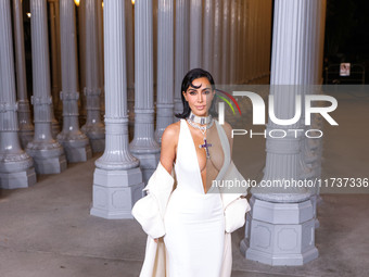 Kim Kardashian wearing a custom Gucci dress and coat with a Tallarico pearl choker, Bvlgari pearl and diamond necklace, and Princess Diana's...