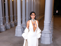 Kim Kardashian wearing a custom Gucci dress and coat with a Tallarico pearl choker, Bvlgari pearl and diamond necklace, and Princess Diana's...