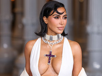 Kim Kardashian wearing a custom Gucci dress and coat with a Tallarico pearl choker, Bvlgari pearl and diamond necklace, and Princess Diana's...