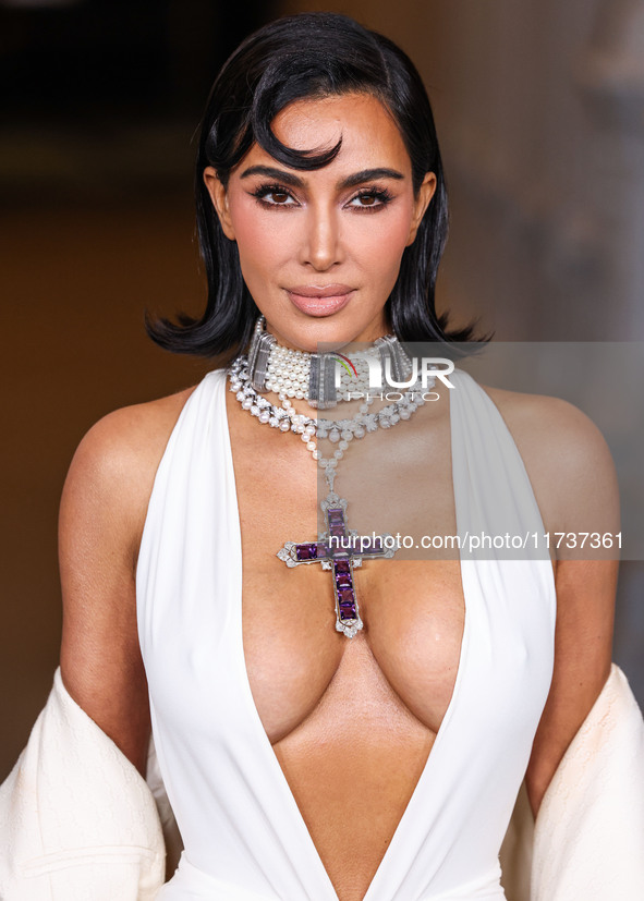 Kim Kardashian wearing a custom Gucci dress and coat with a Tallarico pearl choker, Bvlgari pearl and diamond necklace, and Princess Diana's...