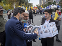 An IRIB News Agency reporter asks a protester about the U.S. 2024 Presidential elections, holding portraits of the election candidates, Dona...