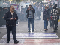 An Iranian photographer takes photographs of the U.S. flag and an Israeli flag during an anti-U.S. and anti-Israel rally marking the anniver...