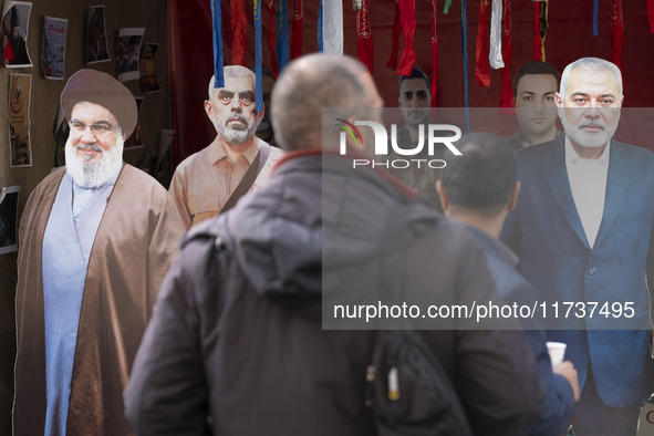 Two Iranian men look at effigies of Lebanon's Hezbollah late leader, Hassan Nasrallah, and two late Hamas leaders, Yahya Sinwar and Ismail H...