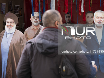 Two Iranian men look at effigies of Lebanon's Hezbollah late leader, Hassan Nasrallah, and two late Hamas leaders, Yahya Sinwar and Ismail H...