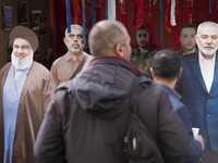 Two Iranian men look at effigies of Lebanon's Hezbollah late leader, Hassan Nasrallah, and two late Hamas leaders, Yahya Sinwar and Ismail H...