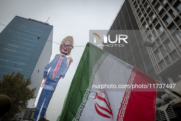 An Iranian man (not pictured) holds up an Iranian flag next to an effigy of Israeli Prime Minister Benjamin Netanyahu while participating in...