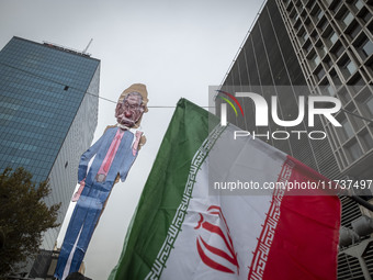 An Iranian man (not pictured) holds up an Iranian flag next to an effigy of Israeli Prime Minister Benjamin Netanyahu while participating in...