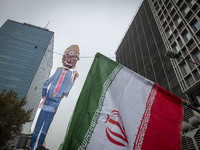 An Iranian man (not pictured) holds up an Iranian flag next to an effigy of Israeli Prime Minister Benjamin Netanyahu while participating in...