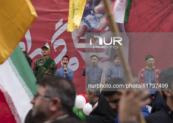 Young Iranian schoolboys perform while standing in front of an anti-U.S. banner during an anti-U.S. and anti-Israel rally marking the annive...