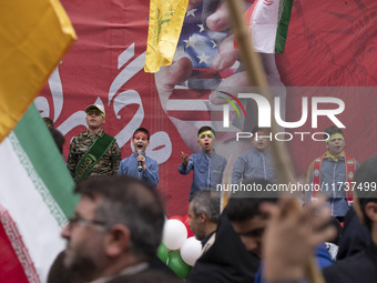 Young Iranian schoolboys perform while standing in front of an anti-U.S. banner during an anti-U.S. and anti-Israel rally marking the annive...