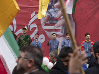 Young Iranian schoolboys perform while standing in front of an anti-U.S. banner during an anti-U.S. and anti-Israel rally marking the annive...