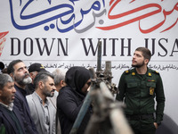 An Islamic Revolutionary Guard Corps (IRGC) military personnel stands in front of an anti-U.S. banner during an anti-U.S. and anti-Israel ra...