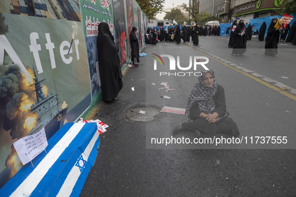 An Iranian woman sits next to an anti-Israeli installation art while participating in an anti-U.S. and anti-Israel rally marking the anniver...