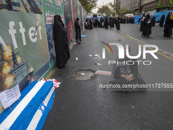 An Iranian woman sits next to an anti-Israeli installation art while participating in an anti-U.S. and anti-Israel rally marking the anniver...