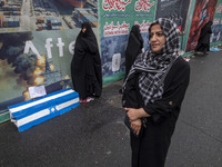 Iranian women stand next to an anti-Israeli installation art while participating in an anti-U.S. and anti-Israel rally marking the anniversa...