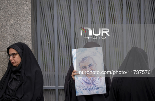 A veiled Iranian woman holds a portrait of Lebanon's Hezbollah late leader, Hassan Nasrallah, while participating in an anti-U.S. and anti-I...