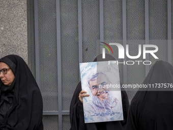 A veiled Iranian woman holds a portrait of Lebanon's Hezbollah late leader, Hassan Nasrallah, while participating in an anti-U.S. and anti-I...