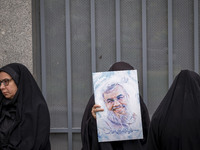 A veiled Iranian woman holds a portrait of Lebanon's Hezbollah late leader, Hassan Nasrallah, while participating in an anti-U.S. and anti-I...