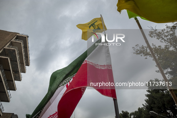 A demonstrator (not pictured) waves an Iranian flag and a flag of Lebanon Hezbollah while participating in an anti-U.S. and anti-Israel rall...