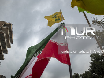 A demonstrator (not pictured) waves an Iranian flag and a flag of Lebanon Hezbollah while participating in an anti-U.S. and anti-Israel rall...