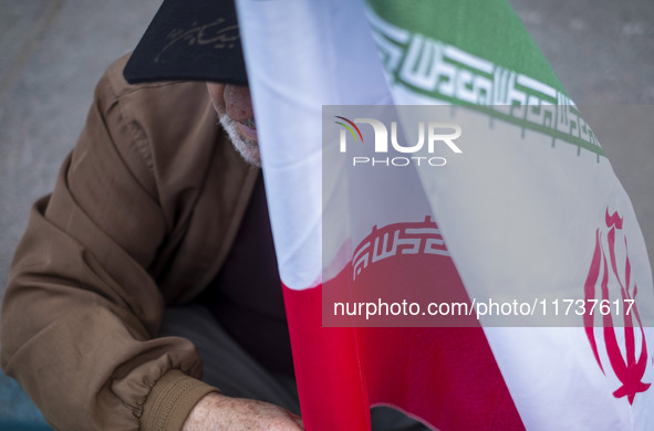 An elderly man holds an Iranian flag during an anti-U.S. and anti-Israel rally marking the anniversary of the U.S. embassy occupation outsid...