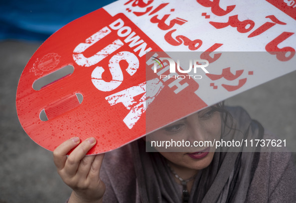 An Iranian woman holds an anti-U.S. placard while participating in an anti-U.S. and anti-Israel rally marking the anniversary of the U.S. em...