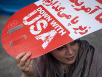 An Iranian woman holds an anti-U.S. placard while participating in an anti-U.S. and anti-Israel rally marking the anniversary of the U.S. em...