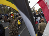 An Iranian demonstrator wears a military uniform and waves an Iranian flag while participating in an anti-U.S. and anti-Israel rally marking...