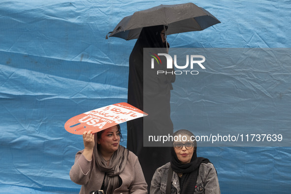 An Iranian woman holds an anti-U.S. placard while participating in an anti-U.S. and anti-Israel rally marking the anniversary of the U.S. em...