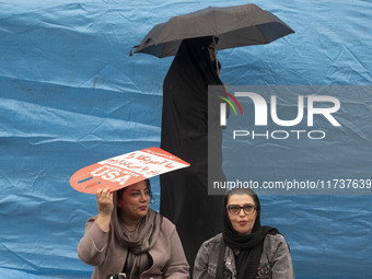 An Iranian woman holds an anti-U.S. placard while participating in an anti-U.S. and anti-Israel rally marking the anniversary of the U.S. em...