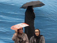 An Iranian woman holds an anti-U.S. placard while participating in an anti-U.S. and anti-Israel rally marking the anniversary of the U.S. em...