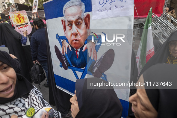 Veiled Iranian demonstrators stand together in front of an anti-Israeli Prime Minister, Benjamin Netanyahu, banner during an anti-U.S. and a...