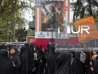 Veiled Iranian demonstrators stand together under an anti-Israeli Prime Minister, Benjamin Netanyahu, banner during an anti-U.S. and anti-Is...