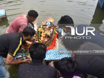 Devotees immerse idols of the Hindu goddess Kali in a pond in Kolkata, India, on November 3, 2024. (