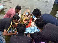 Devotees immerse idols of the Hindu goddess Kali in a pond in Kolkata, India, on November 3, 2024. (