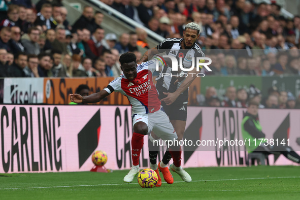 Arsenal's Bukayo Saka battles for possession with Newcastle United's Joelinton during the Premier League match between Newcastle United and...