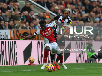 Arsenal's Bukayo Saka battles for possession with Newcastle United's Joelinton during the Premier League match between Newcastle United and...