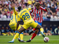 Antoine Griezmann of Atletico de Madrid (right) is in action with the ball against Dario Essugo of UD Las Palmas (left) during the La Liga E...