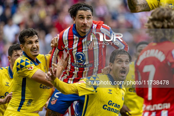 Jose Gimenez of Atletico de Madrid (C) fights for the ball against Alex Munoz (L) and Jose Gomez Campana (R) of UD Las Palmas during the La...