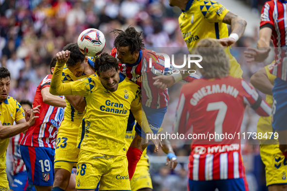 Jose Gimenez of Atletico de Madrid (C) fights for the ball against Alex Munoz (L) and Jose Gomez Campana (R) of UD Las Palmas during the La...