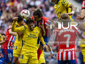 Jose Gimenez of Atletico de Madrid (C) fights for the ball against Alex Munoz (L) and Jose Gomez Campana (R) of UD Las Palmas during the La...