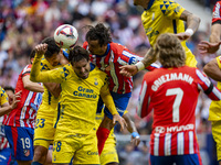 Jose Gimenez of Atletico de Madrid (C) fights for the ball against Alex Munoz (L) and Jose Gomez Campana (R) of UD Las Palmas during the La...